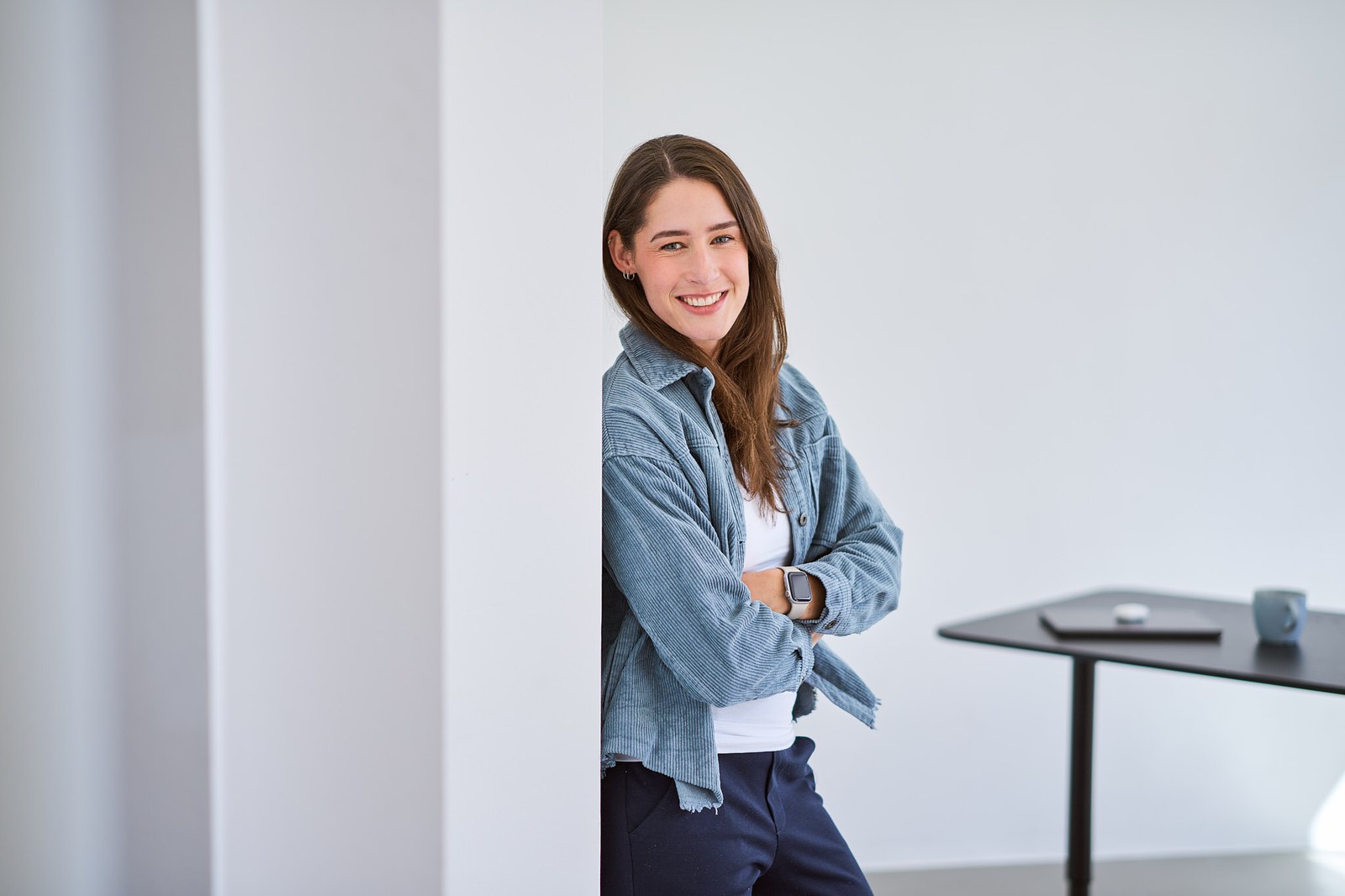 Nina Benfer, Freelancerin Social Media Kampagnen, lächelt vor unscharfem Hintergrund.